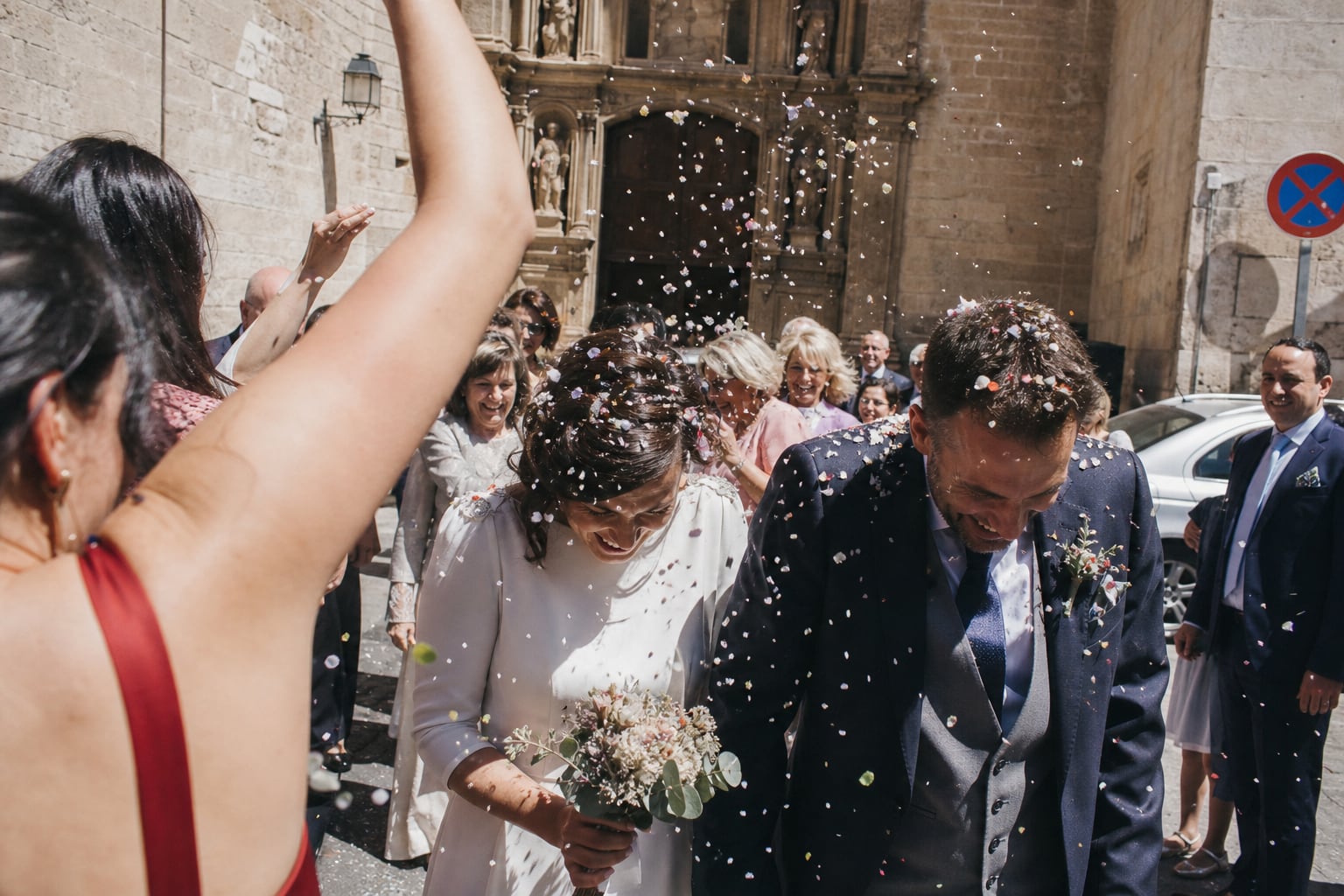 Guests throwing confetti over the newlyweds outside a church in Valencia